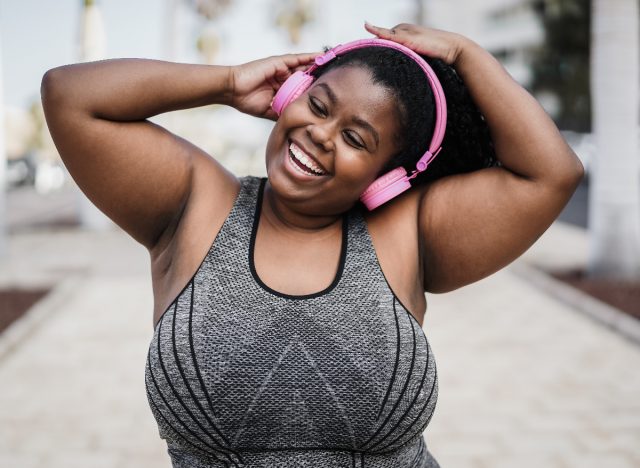happy woman listening to music outdoors, cardio dance, quick workout